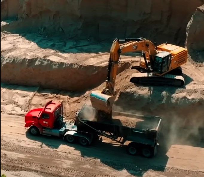 Excavator loading fill into a dump truck at the Mound City TA Travel Center project