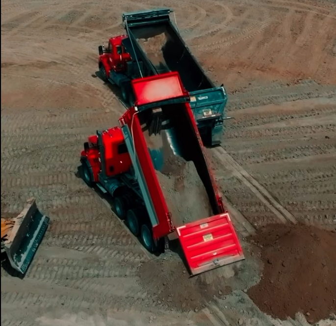 Dump trucks unloading fill on the pad at the Mound City TA Travel Center project